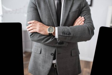 cropped view of trader in formal wear and wristwatch standing with crossed arms clipart