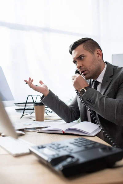 Comerciante Hablando Por Teléfono Fijo Cerca Portátil Café Para Oficina — Foto de Stock