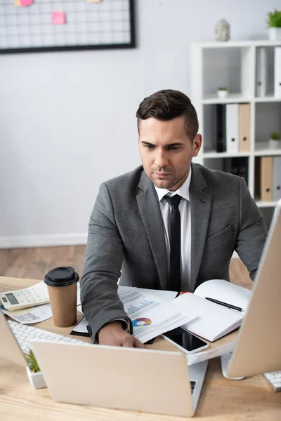 Handelaar Met Behulp Van Laptop Buurt Van Koffie Gaan Papieren — Stockfoto