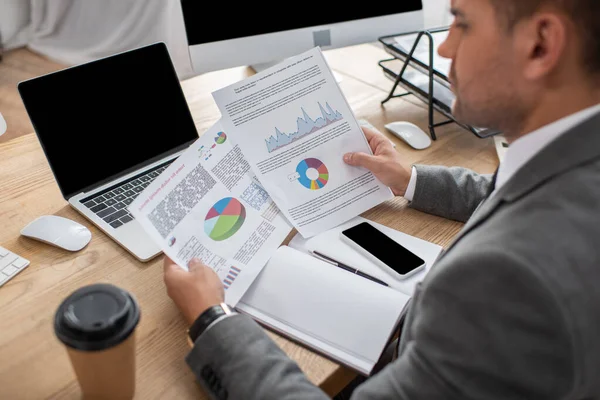 Partial View Trader Holding Papers Infographics Smartphone Laptop Blank Screen — Stock Photo, Image