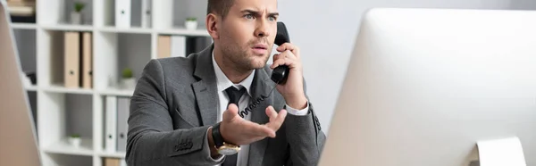 Chockad Näringsidkare Pekar Med Handen Datorskärm När Talar Fast Telefon — Stockfoto