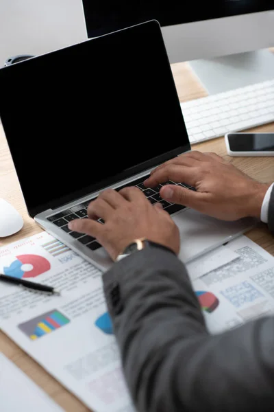 Partial View Trader Typing Laptop Papers Graphs Charts Blurred Foreground — Stock Photo, Image