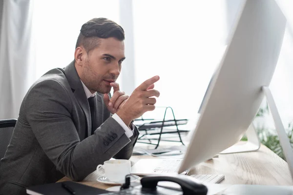 Concentrated Trader Pointing Finger Monitor Blurred Foreground — Stock Photo, Image