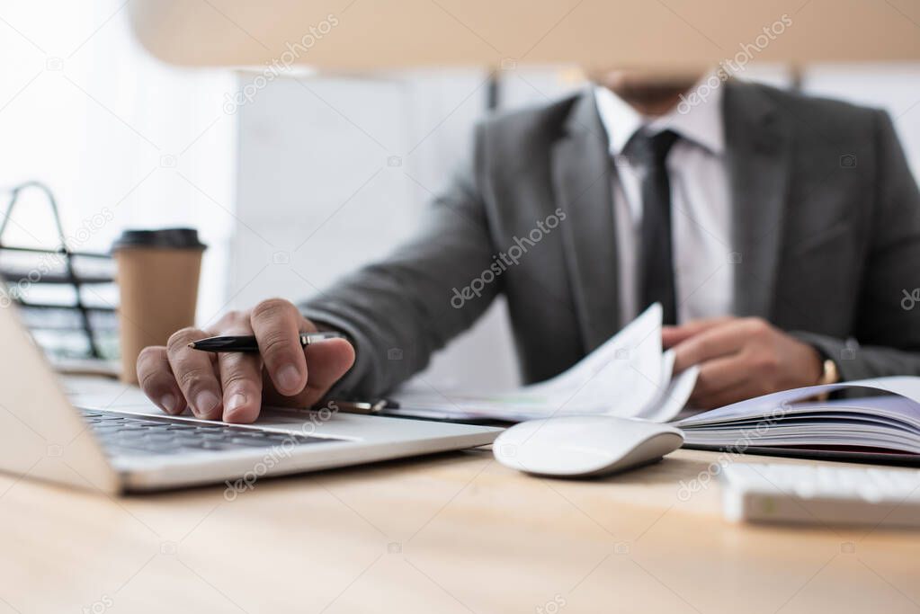 cropped view of trader using laptop at workplace on blurred foreground, banner