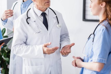 Steteskoplu doktor hastanede hemşireyle konuşuyor. 
