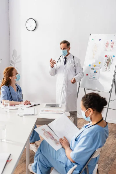 Médecin Masqué Près Tableau Feuilles Avec Des Documents Près Collègues — Photo