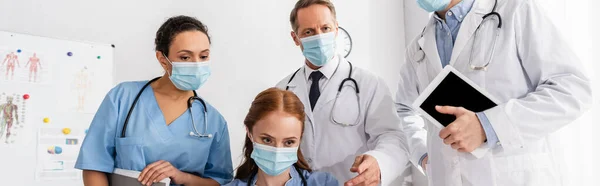 Multiethnische Ärzte Medizinischen Masken Mit Digitalem Tablet Der Klinik Banner — Stockfoto