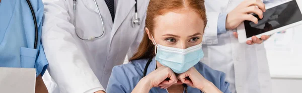 Νοσοκόμα Ιατρική Μάσκα Κοιτάζει Μακριά Κοντά Συναδέλφους Πανό — Φωτογραφία Αρχείου