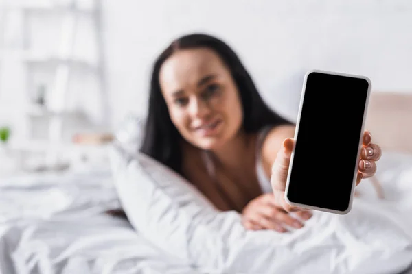 Junge Brünette Frau Bett Präsentiert Smartphone Verschwommener Hintergrund — Stockfoto