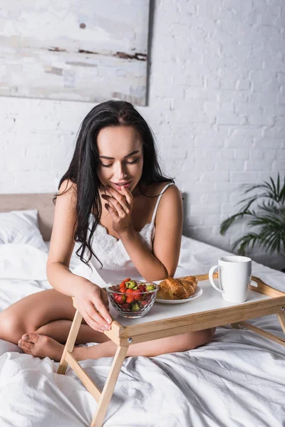 Joven Morena Mujer Tomando Croissant Fresa Para Desayuno Cama — Foto de Stock