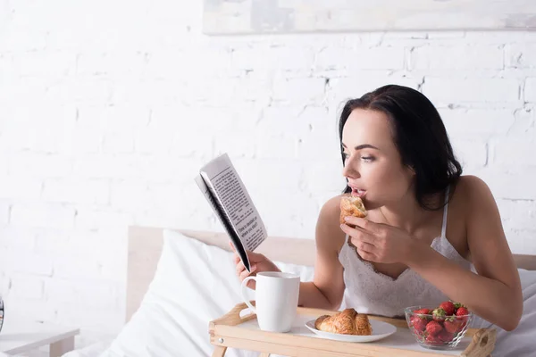 Young Brunette Woman Having Croissant Strawberry Cocoa Breakfast While Reading — Stock Photo, Image