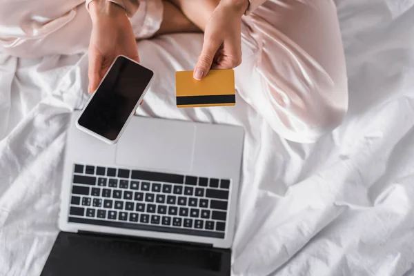 Beskärd Över Kvinnan Sitter Sängen Med Smartphone Kreditkort Och Bärbar — Stockfoto