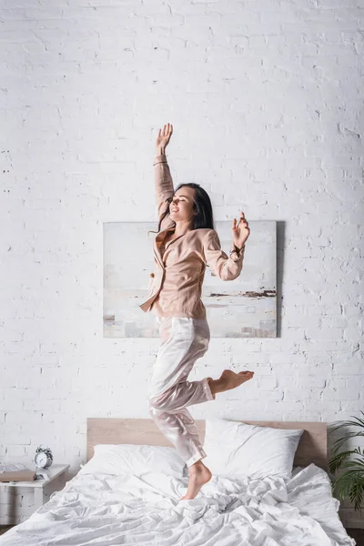 Νεαρή Μελαχρινή Γυναίκα Πηδάει Στο Κρεβάτι Πρωί — Φωτογραφία Αρχείου