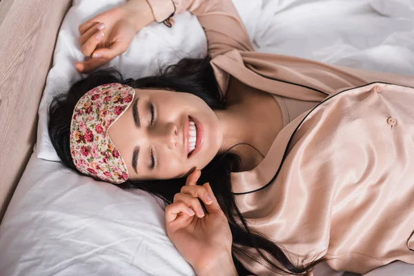 Vista Superior Joven Morena Sonriente Tumbada Cama Máscara Del Sueño — Foto de Stock