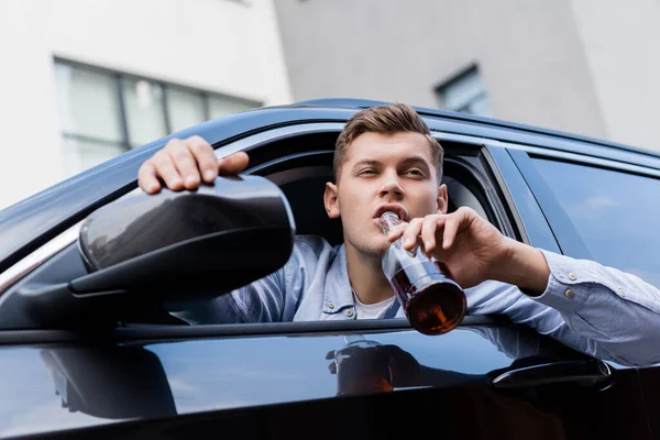 Berusad Man Dricker Alkohol Medan Tittar Genom Bilfönstret — Stockfoto