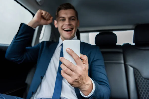 Smartphone Hand Cheerful Businessman Showing Yeah Gesture Blurred Background Car — Stock Photo, Image