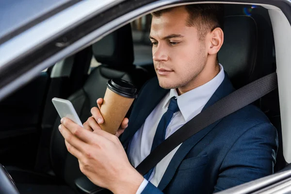 Jovem Empresário Usando Smartphone Segurando Café Para Assento Motorista Carro — Fotografia de Stock