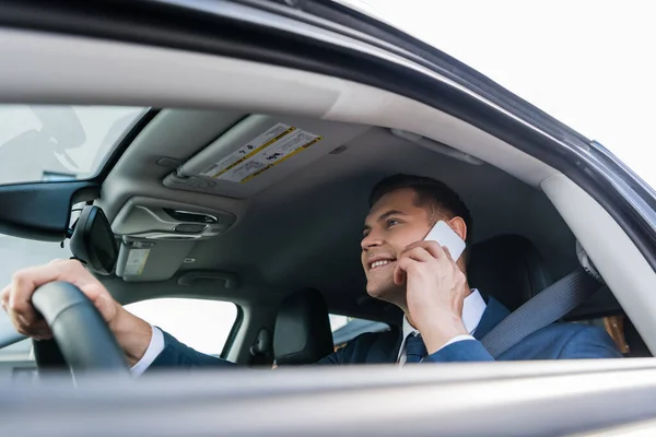 Wesoły Biznesmen Rozmawiający Smartfonie Podczas Jazdy Samochodem Niewyraźnym Pierwszym Planie — Zdjęcie stockowe