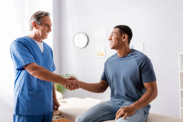 Glad Kiropraktor Skakar Hand Med Afrikansk Amerikansk Patient — Stockfoto