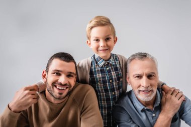 Baba ve büyükbabaya sarılan mutlu çocuk Grey 'de yalnız başına ellerini tutuyor.