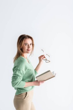 Gözlüklü neşeli bir kadın ve beyaz bir kitap.