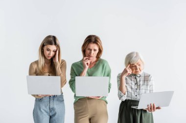 Beyaz dizüstü bilgisayar kullanan üç kuşak düşünceli kadın.