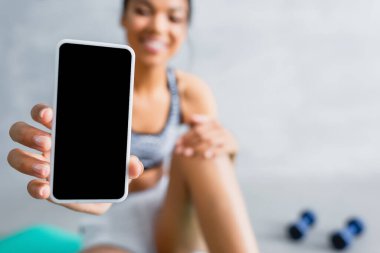 Afrika kökenli Amerikalı sporcunun elinde cep telefonuyla arka planda bulanıklık olan görüntüsü