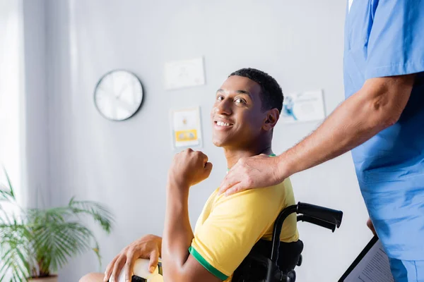 Зрелый Врач Трогает Плечо Веселого Спортсмена Инвалида Клинике — стоковое фото
