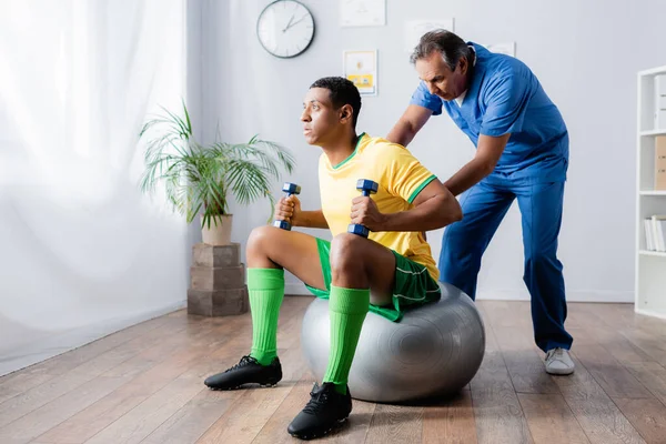 Deportista Afroamericano Haciendo Ejercicio Con Pesas Pelota Fitness Cerca Fisioterapeuta —  Fotos de Stock