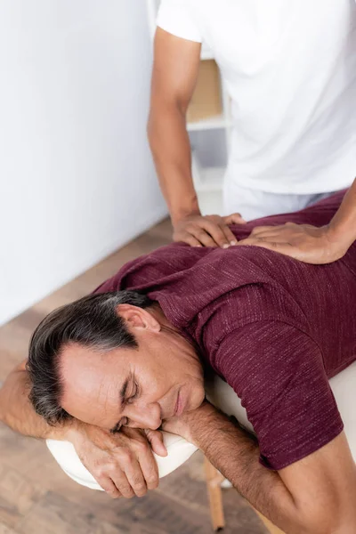 Jovem Massagista Afro Americano Massageando Costas Homem Meia Idade Mesa — Fotografia de Stock