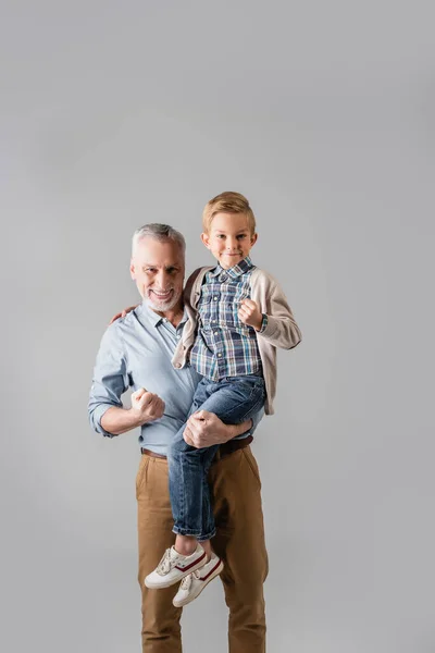 Upphetsad Man Håller Barnbarn Samtidigt Visa Vinna Gest Tillsammans Isolerad — Stockfoto