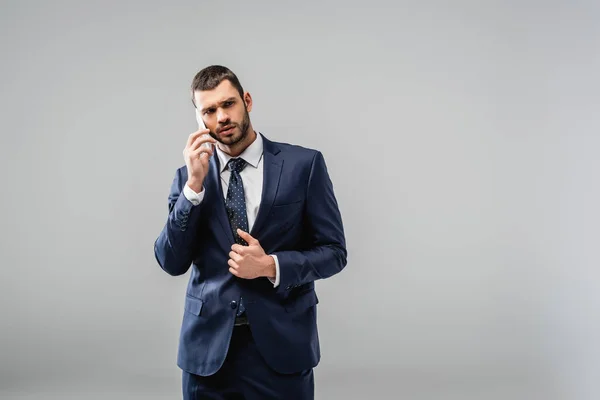 Eftertänksam Affärsman Kostym Talar Mobiltelefon Isolerad Grå — Stockfoto