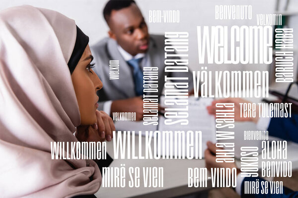 arabian businesswoman near multicultural business partners on blurred background, welcome word in different languages illustration