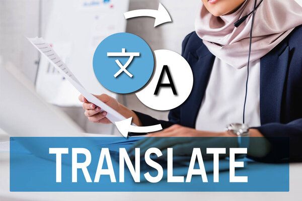 cropped view of interpreter holding documents while typing on laptop, translate word near icons and arrows illustration