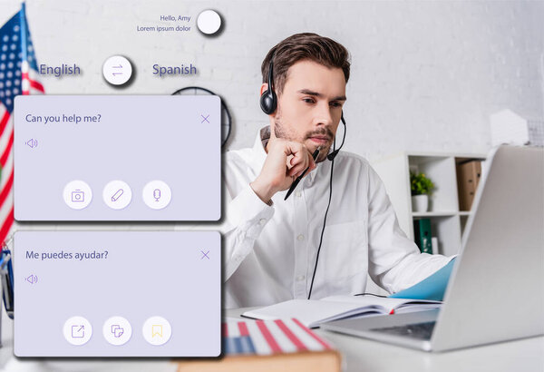 молодой переводчик в наушниках, работающий рядом с ноутбуком на размытом переднем плане, иллюстрация интерфейса приложения перевода
