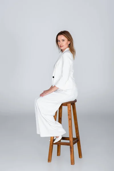Full Length Woman White Outfit Sitting Stool Grey — Stock Photo, Image