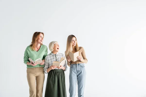 Três Geração Mulheres Felizes Segurando Livros Olhando Para Longe Isolado — Fotografia de Stock