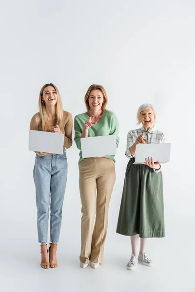 Full Length Three Generation Cheerful Women Pointing Fingers Holding Laptops — Stock Photo, Image