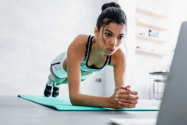 African American Sportswoman Practicing Plank Pose While Looking Laptop Blurred — Stock Photo, Image