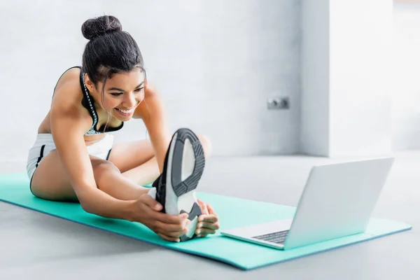 Cheerful African American Woman Stretching While Sitting Fitness Mat Laptop — Stock Photo, Image