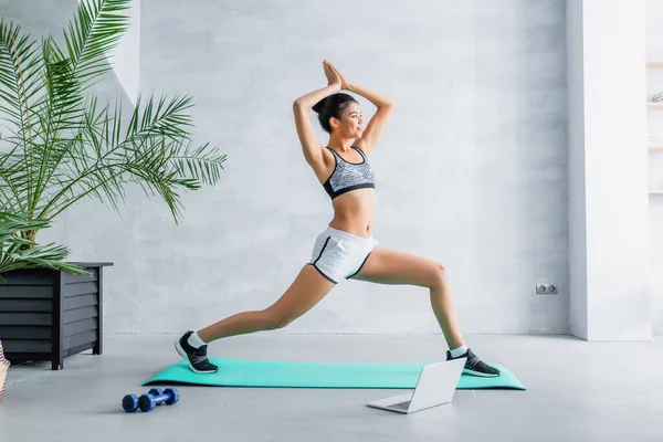 Young African American Sportswoman Exercising Warrior Pose Laptop Dumbbells Home — Stock Photo, Image