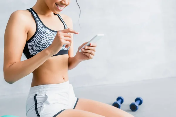 Cropped View African American Sportswoman Chatting Smartphone Dumbbells Blurred Background — Stock Photo, Image