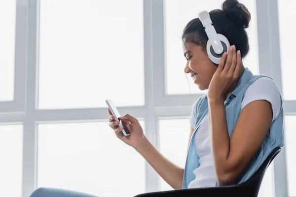 Vista Lateral Mujer Afroamericana Charlando Teléfono Inteligente Mientras Escucha Música — Foto de Stock