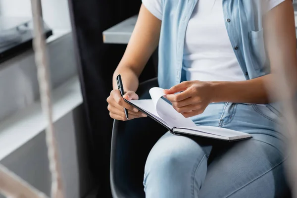 Vista Recortada Mujer Afroamericana Sosteniendo Cuaderno Una Pluma Mientras Está —  Fotos de Stock