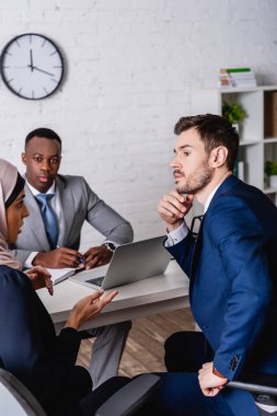 Arap ve Afro-Amerikan iş ortaklarıyla görüşürken düşünceli tercüman Chin 'e dokunuyor.