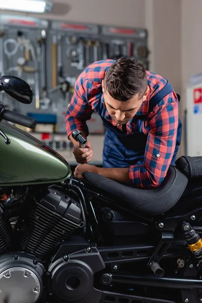 Jovem Mecânico Segurando Chave Encaixe Enquanto Examina Motocicleta Oficina — Fotografia de Stock