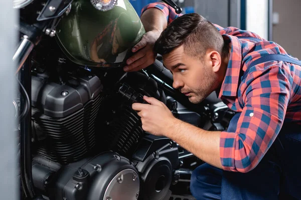 Jovem Técnico Verificando Motocicleta Com Lanterna Elétrica Foreground Borrado — Fotografia de Stock