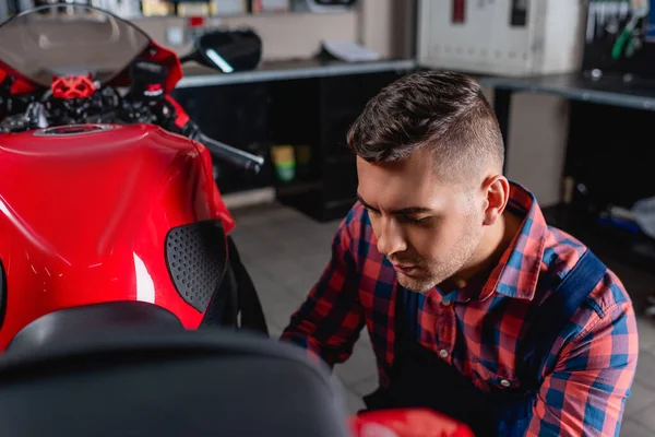 Ung Mekaniker Plaid Shirt Undersøger Motorcykel Værksted Sløret Forgrund - Stock-foto