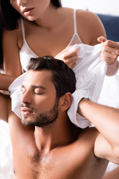 Sexy Woman Undressing Sensual Man Closed Eyes Shirt Indoors — Stock Photo, Image