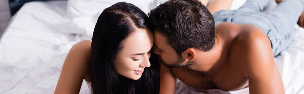 sensual young couple with closed eyes lying on bed, banner